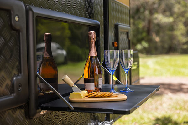 Wine with cheese and crackers on a platter on fold out caravan table
