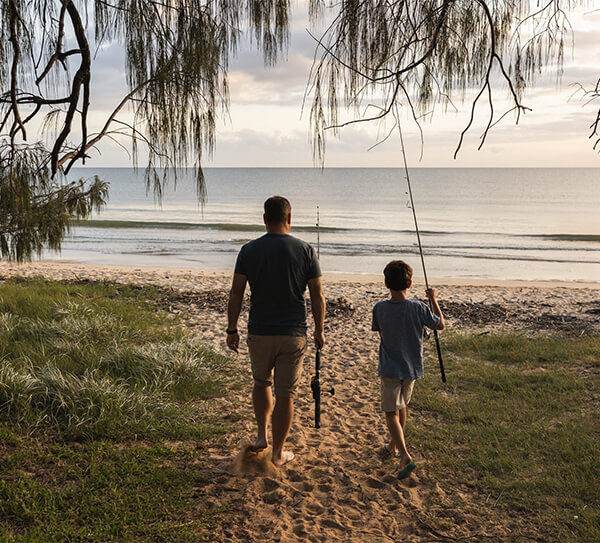 Caravans and camping in Queensland - father and son fishing at the Sunshine Coast beach